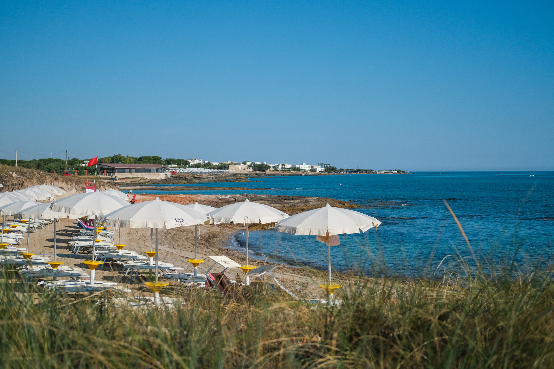 Spiaggia privata di Torre Guaceto Greenblu Resort con ombrelloni e lettini sul mare